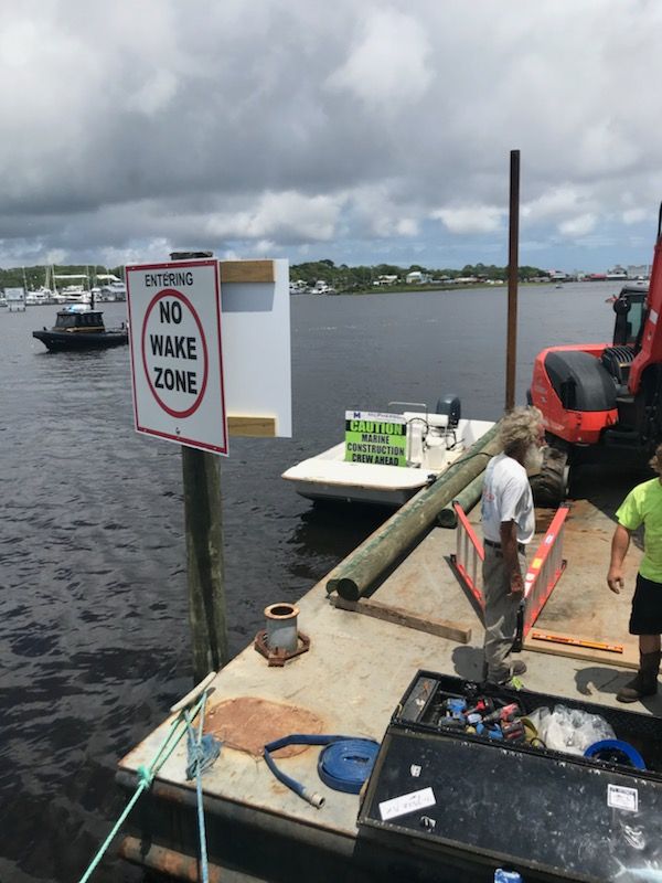 A dock with a sign that says no wake zone.