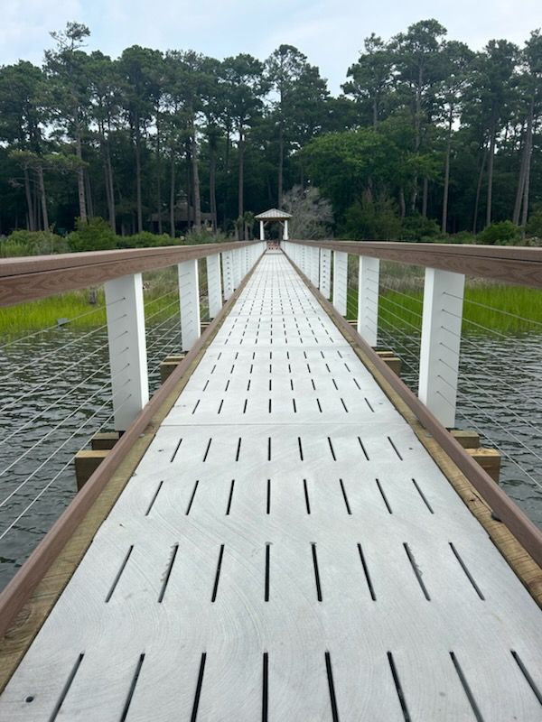 A bridge over a body of water with trees in the background.