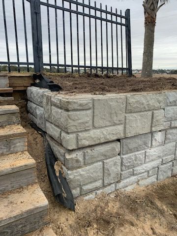 A brick wall with stairs and a fence in the background.
