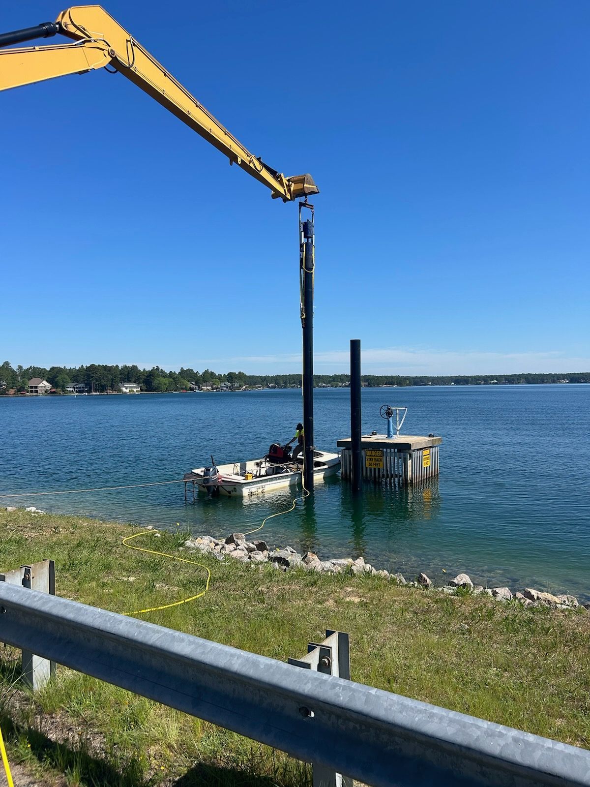 A crane is working on a dock in the middle of a lake.