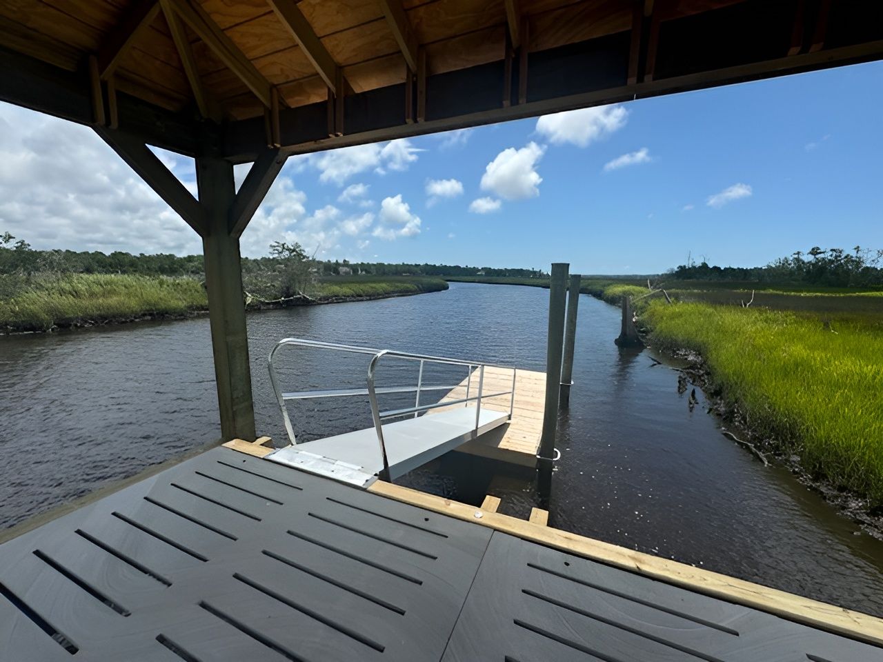 A view of a river from a gazebo with a dock in the foreground