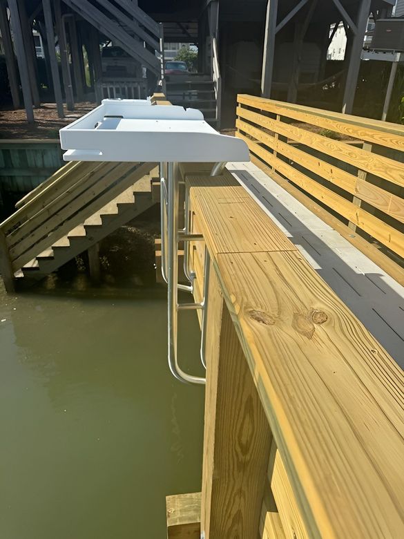 A wooden bridge over a body of water with stairs leading up to it.