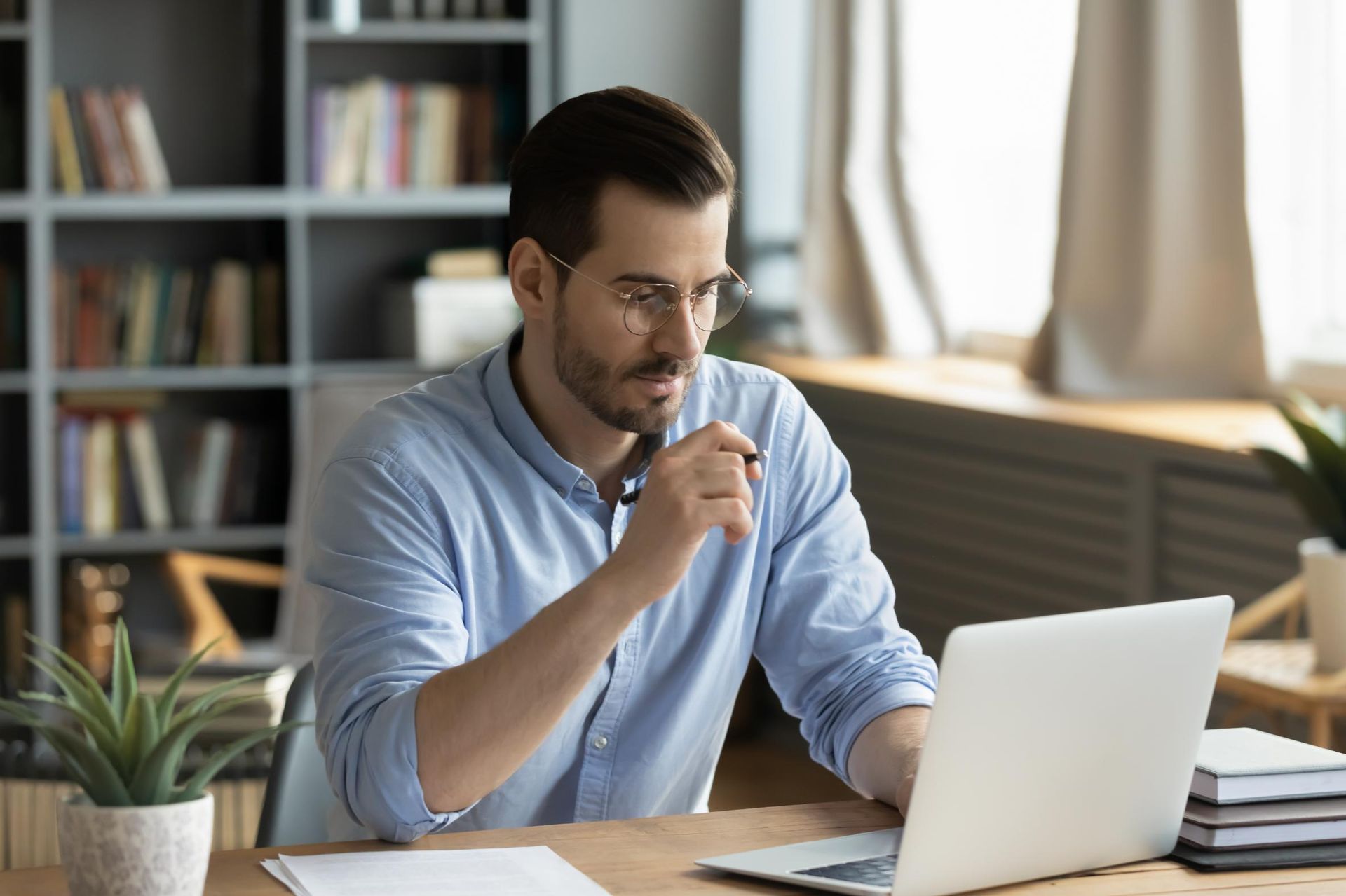 A man is sitting at a desk using a laptop computer.