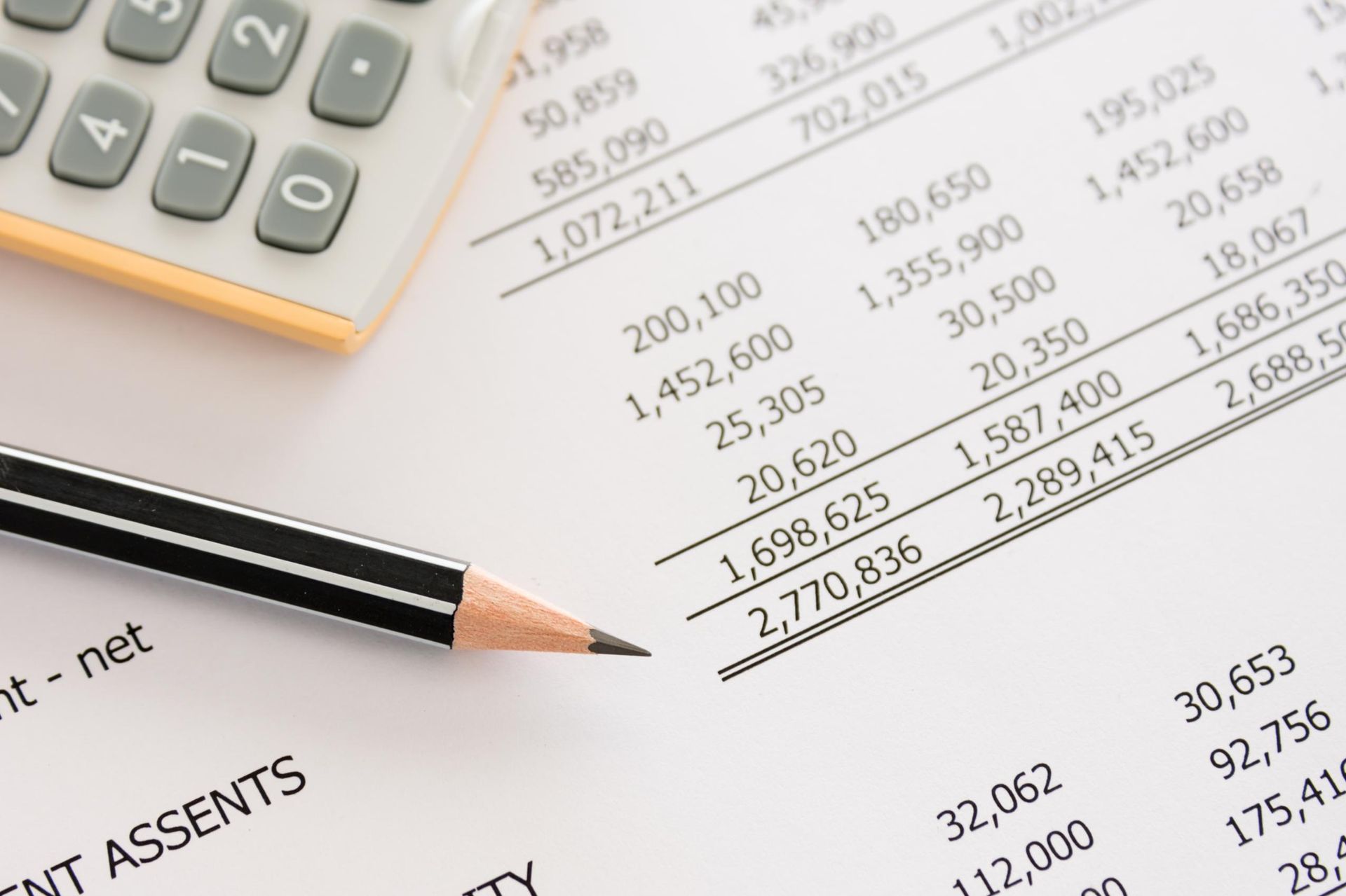 A calculator and pencil on top of a sheet of paper that says net assents
