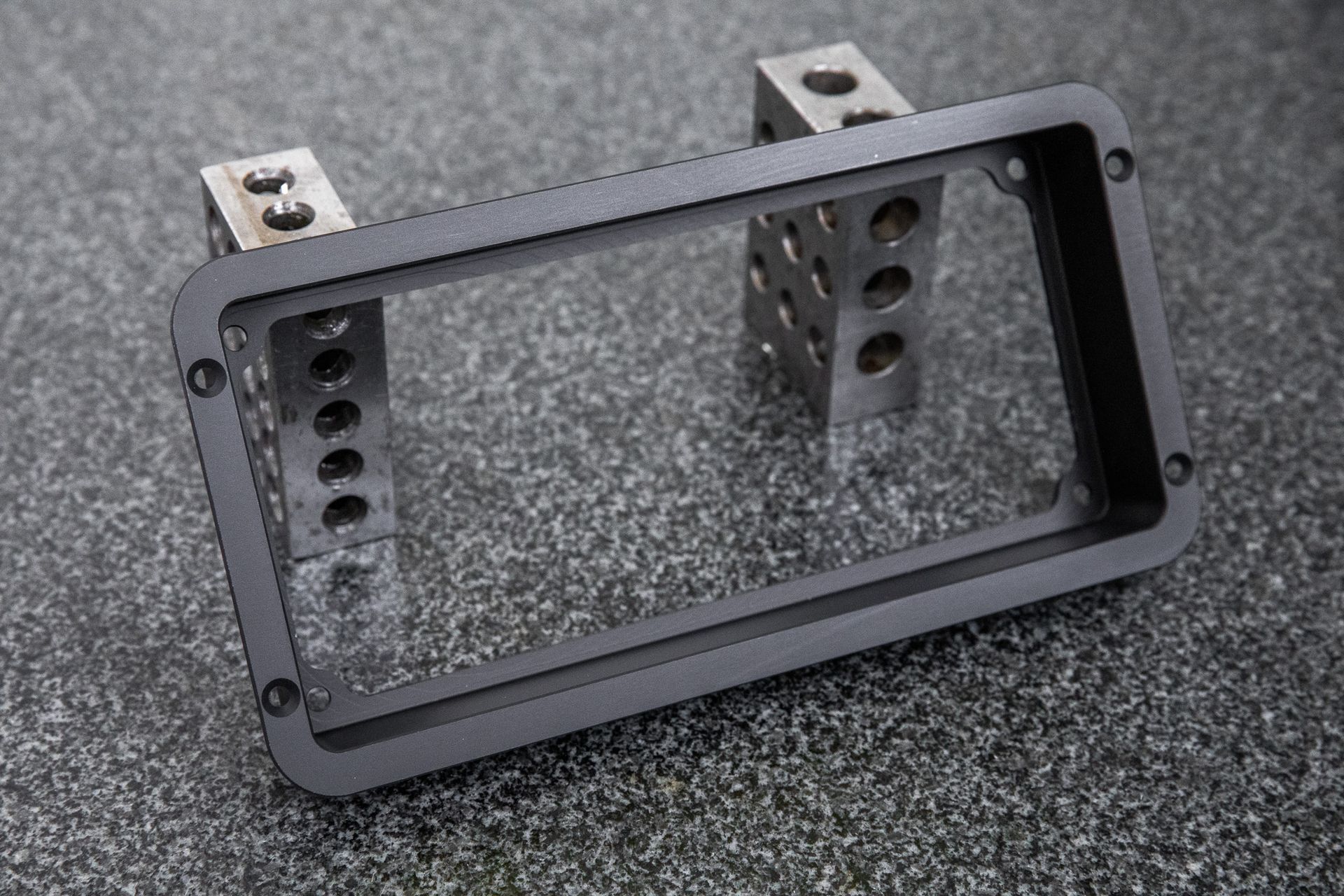A black billet dash mount bezel made by Precision Metal Craft for a Holley 6.8 Pro.