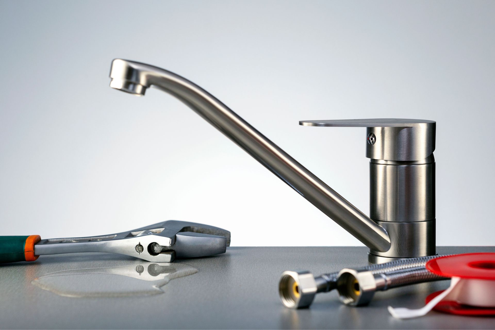 A faucet is sitting on a table next to tools