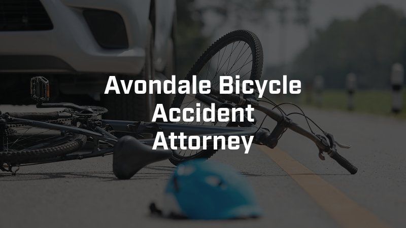 A bicycle is laying on the side of the road next to a helmet.