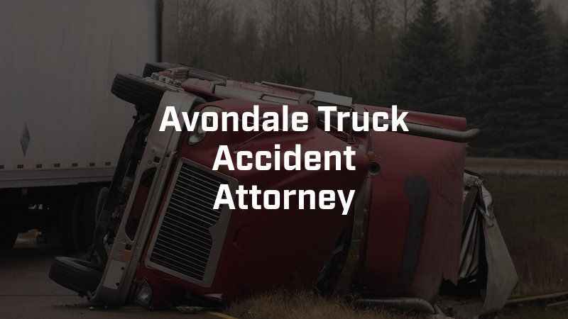 A red truck is turned over on the side of the road.