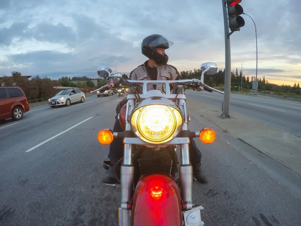 A man is riding a red motorcycle on a highway