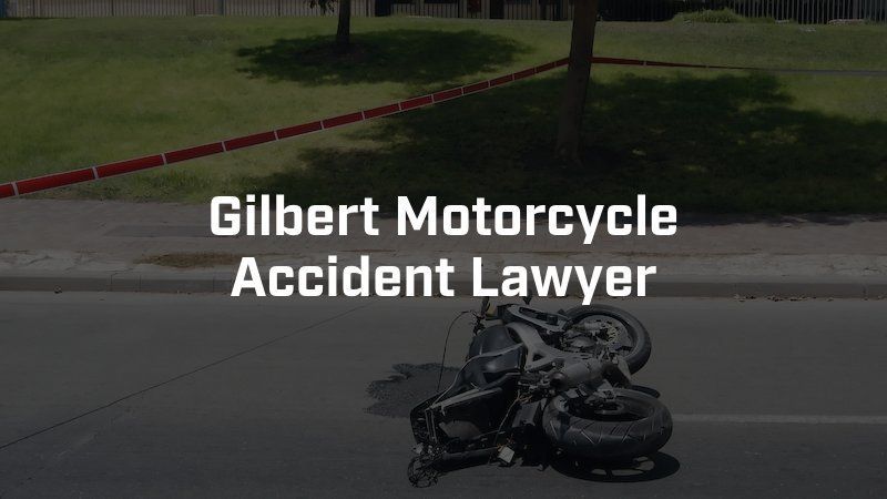 A motorcycle is laying on the side of the road with the words gilbert motorcycle accident lawyer above it