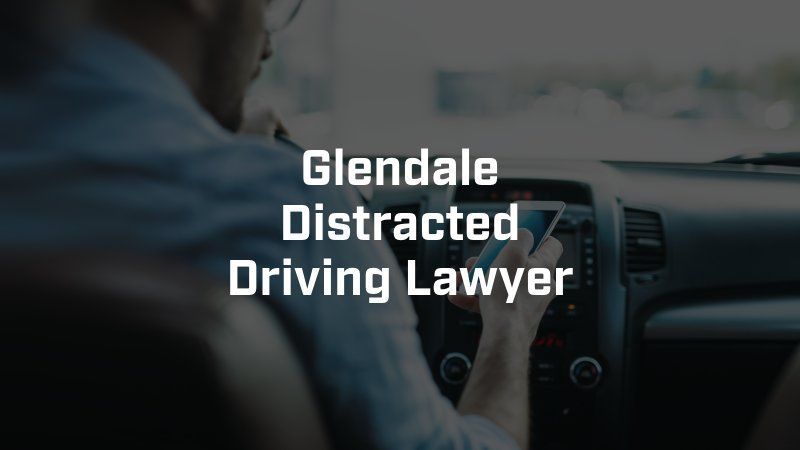 A man is sitting in a car looking at his phone.