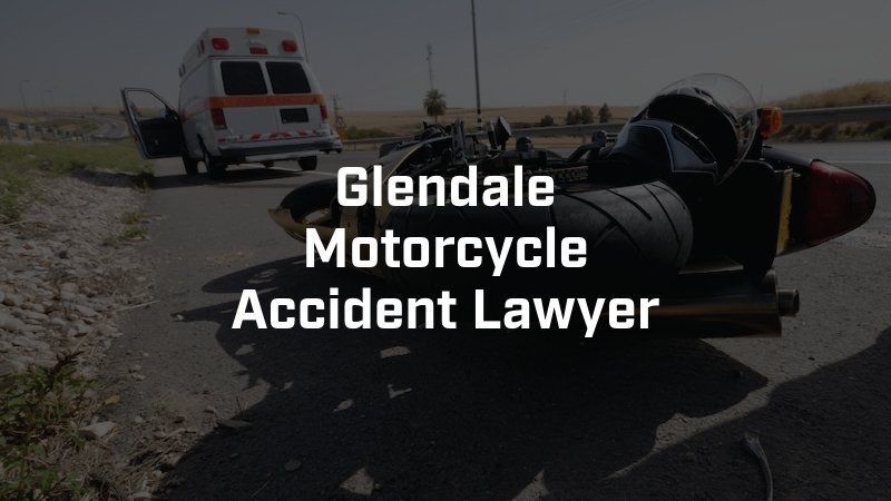 A motorcycle is laying on the side of the road next to an ambulance.