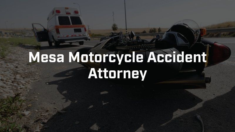 A motorcycle accident on a road with an ambulance in the background