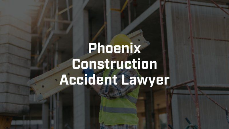 A construction worker is holding a piece of wood in front of a building under construction.
