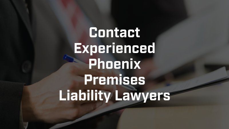 A person writing on a clipboard with the words contact experienced phoenix premises liability lawyers