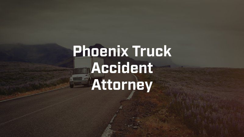 A truck is driving down a road next to a field.
