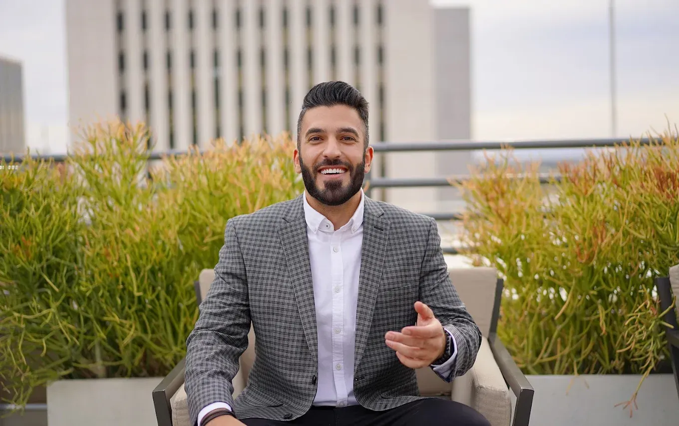 A man in a suit is sitting in a chair on a balcony.