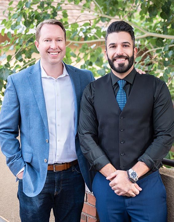 Two men in suits and ties are posing for a picture.