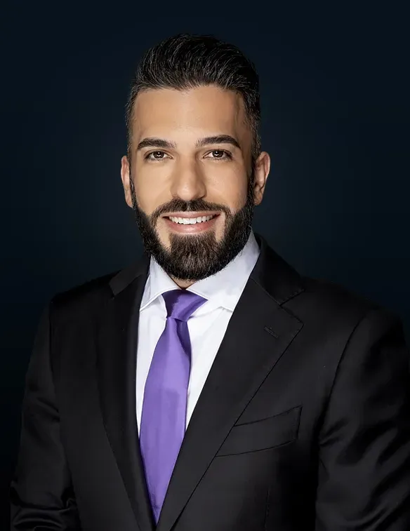A man in a suit and tie is smiling for the camera.