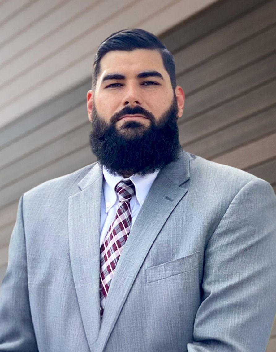 A man with a beard is wearing a suit and tie.