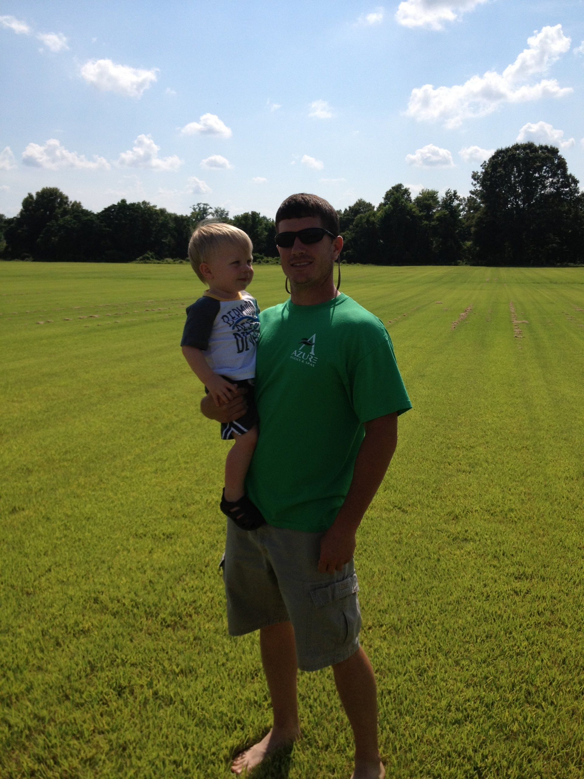 Grass — Man Carrying a Child on Field of Grass in Bastrop, LA