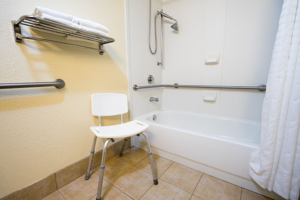 A Handicapped Bathroom With A Bathtub And A Chair  — My Coast Projects in West Gosford, NSW