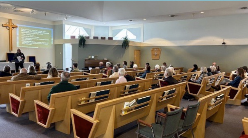 Mike Short and Suzanne Pettigrew are talking in front of a rescue boat.