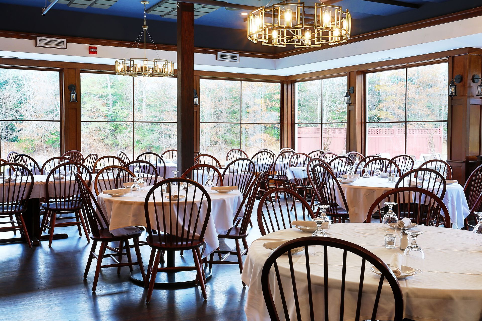A large dining room with tables and chairs and a chandelier