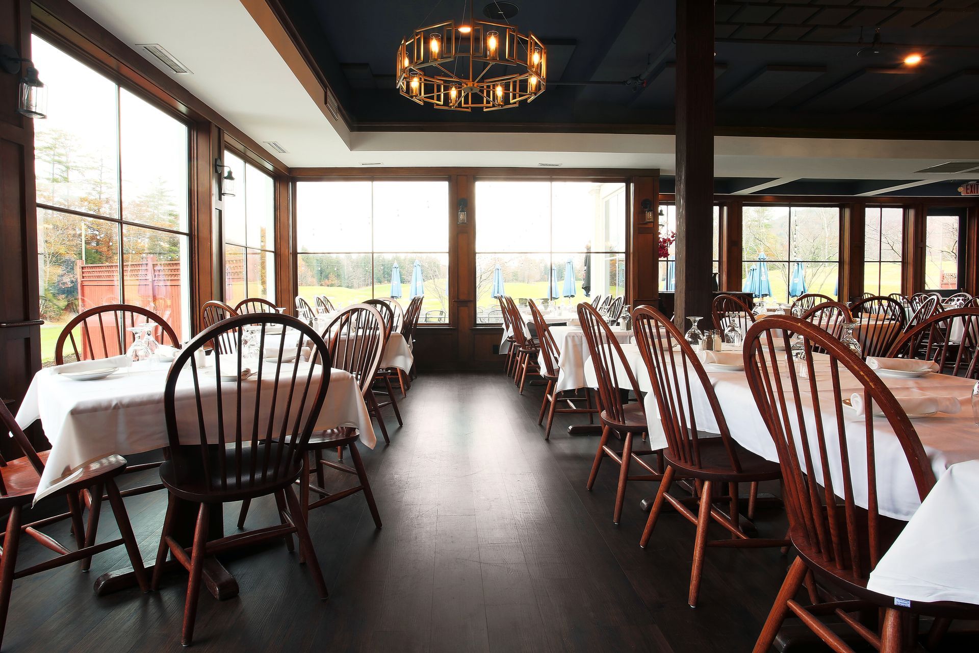 A dining room with tables and chairs and a chandelier