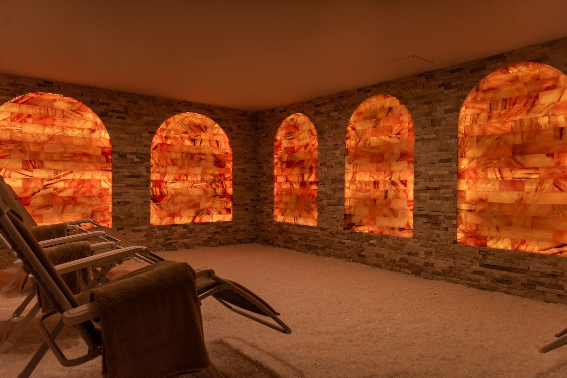 a room with chairs and arched windows filled with salt rocks .