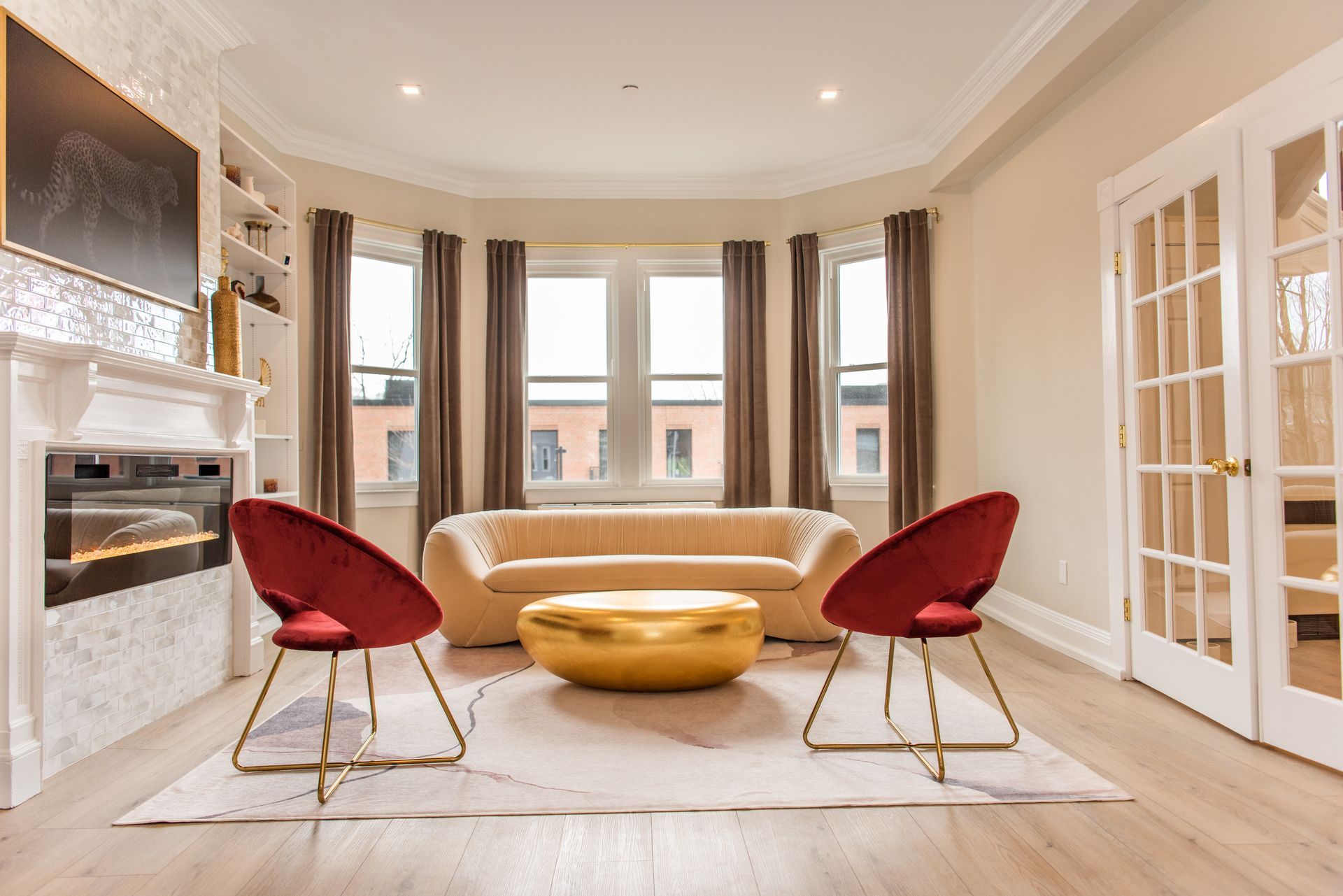 a living room with a couch , two chairs , a coffee table and a fireplace .