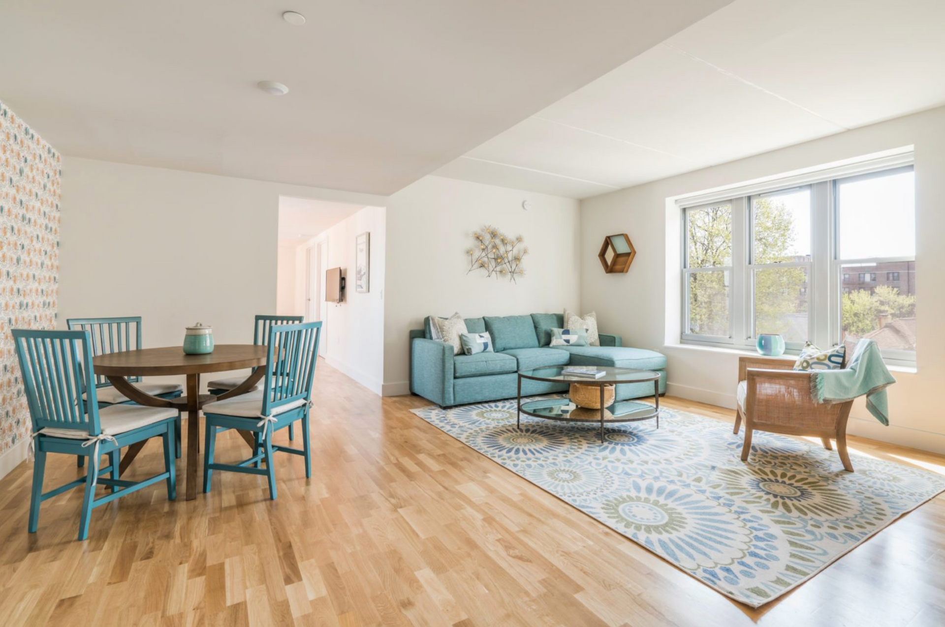 a living room with a blue couch , table and chairs .