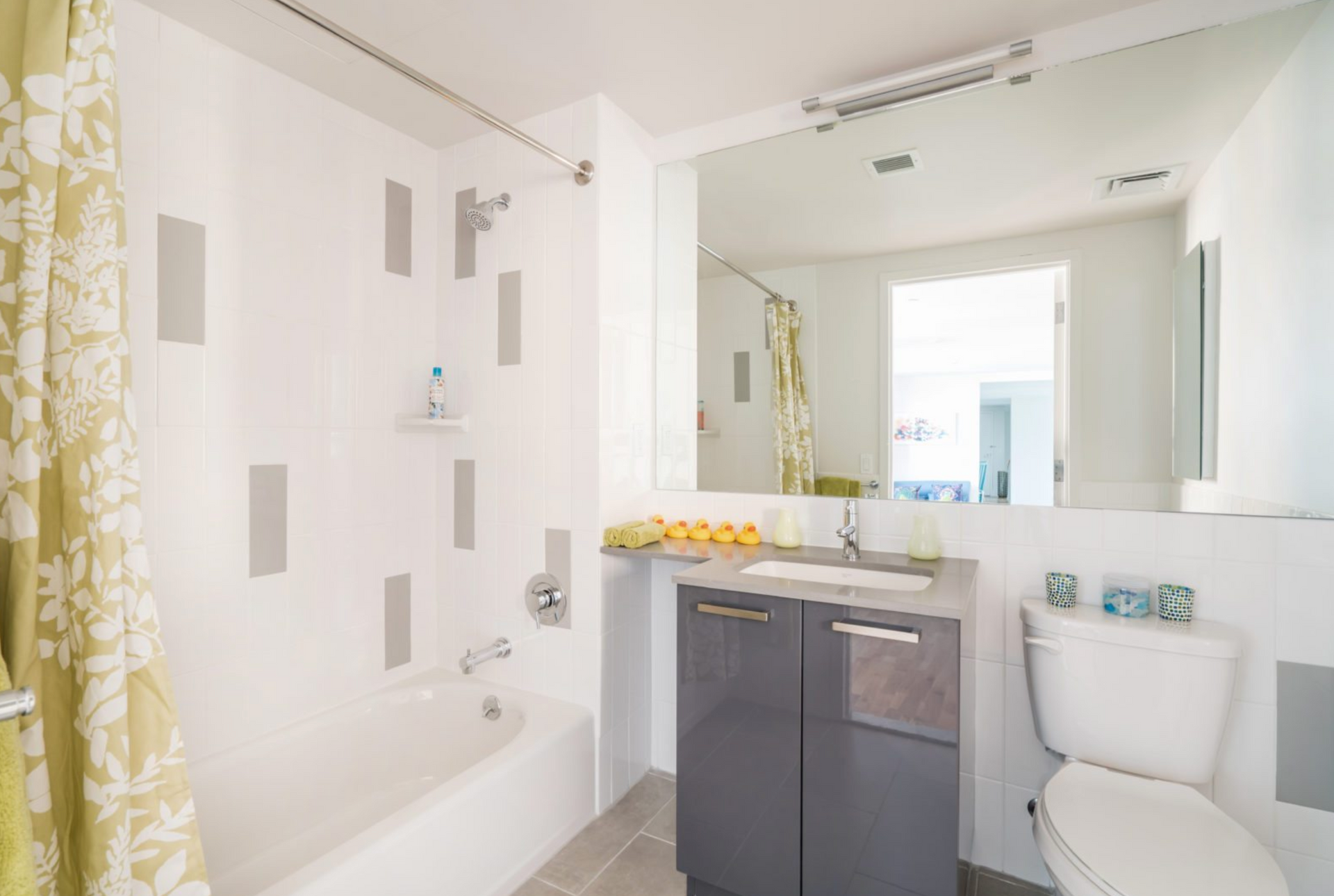 a bathroom with a toilet , sink , tub and mirror .