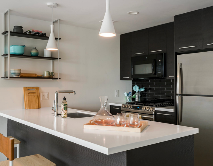 a kitchen with black cabinets and stainless steel appliances