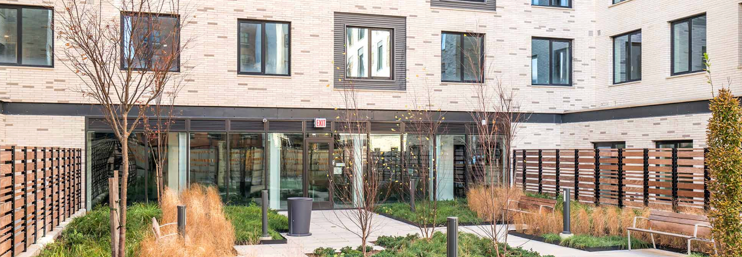 a large brick building with a garden in front of it .