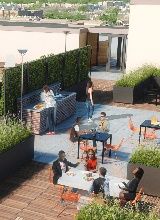 a group of people are sitting at tables on a rooftop patio .