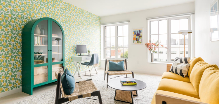a living room with a yellow couch and a green cabinet .