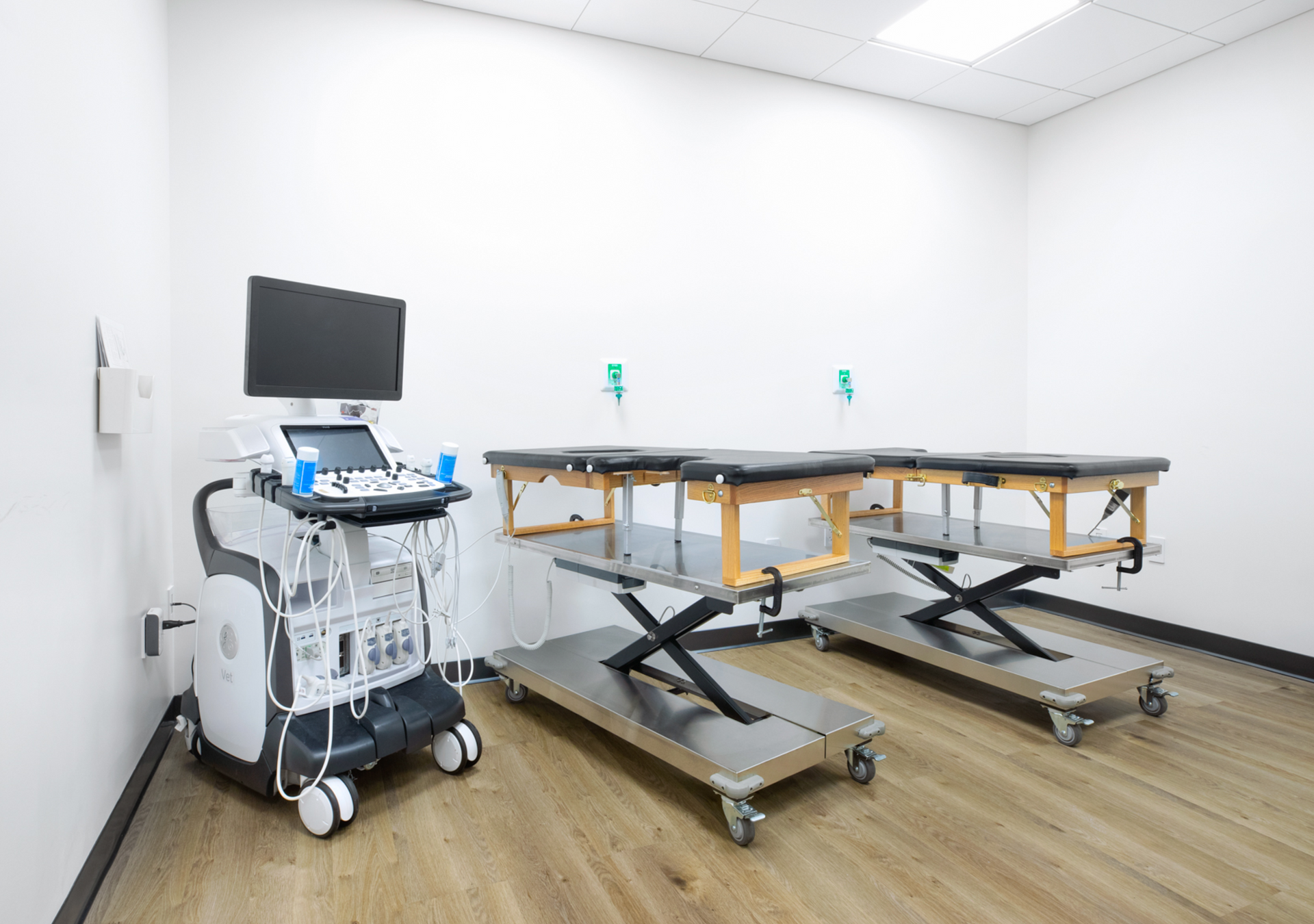 A room with two tables and an ultrasound machine.