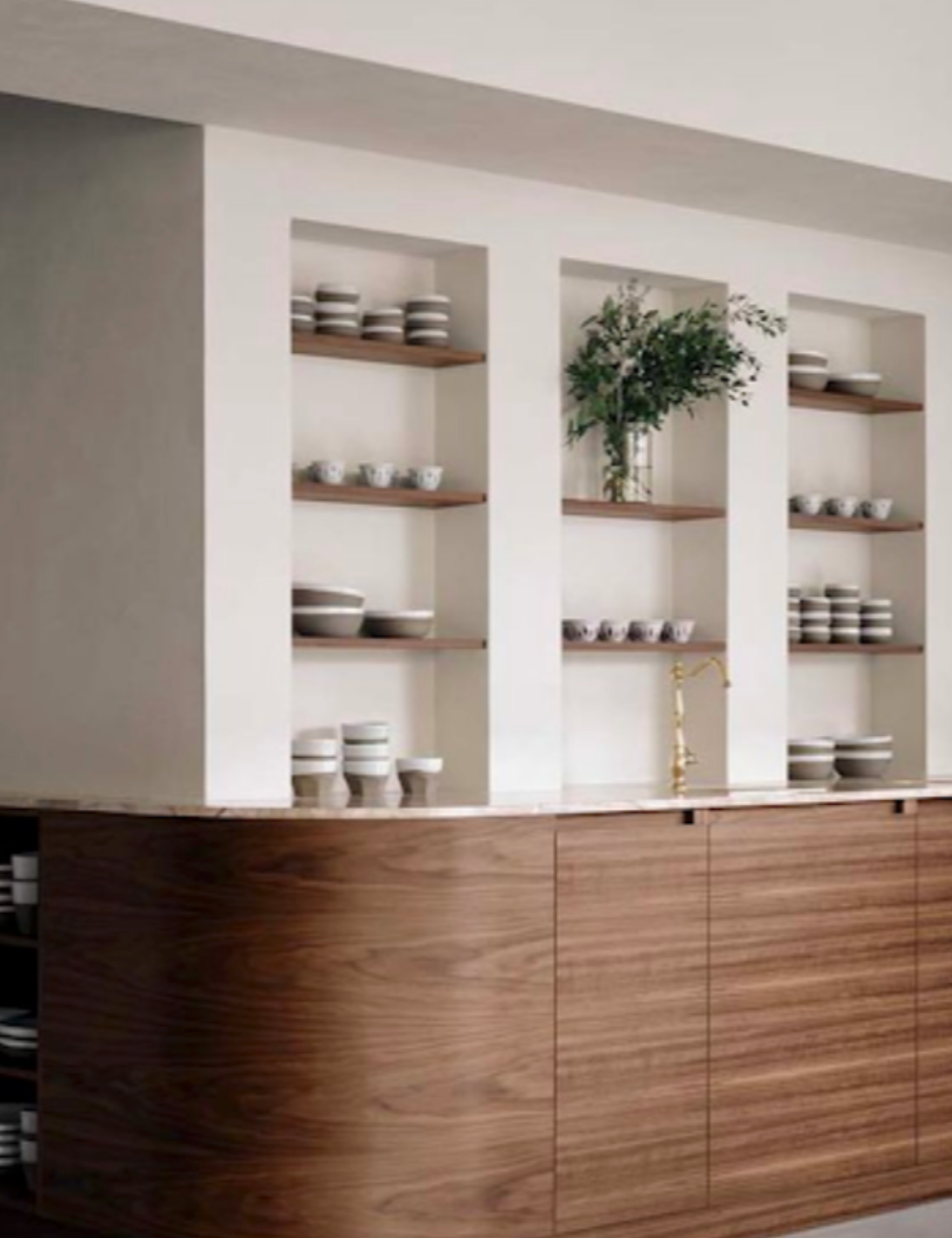 A kitchen with a wooden counter and shelves filled with bowls and plates.