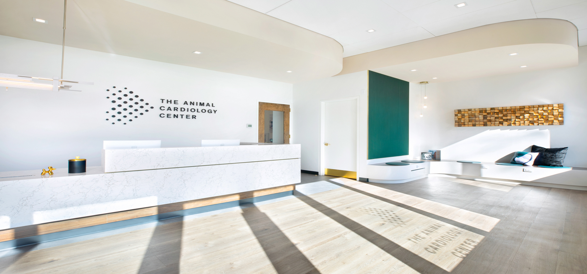 A dental office with a white reception desk and a wooden floor.