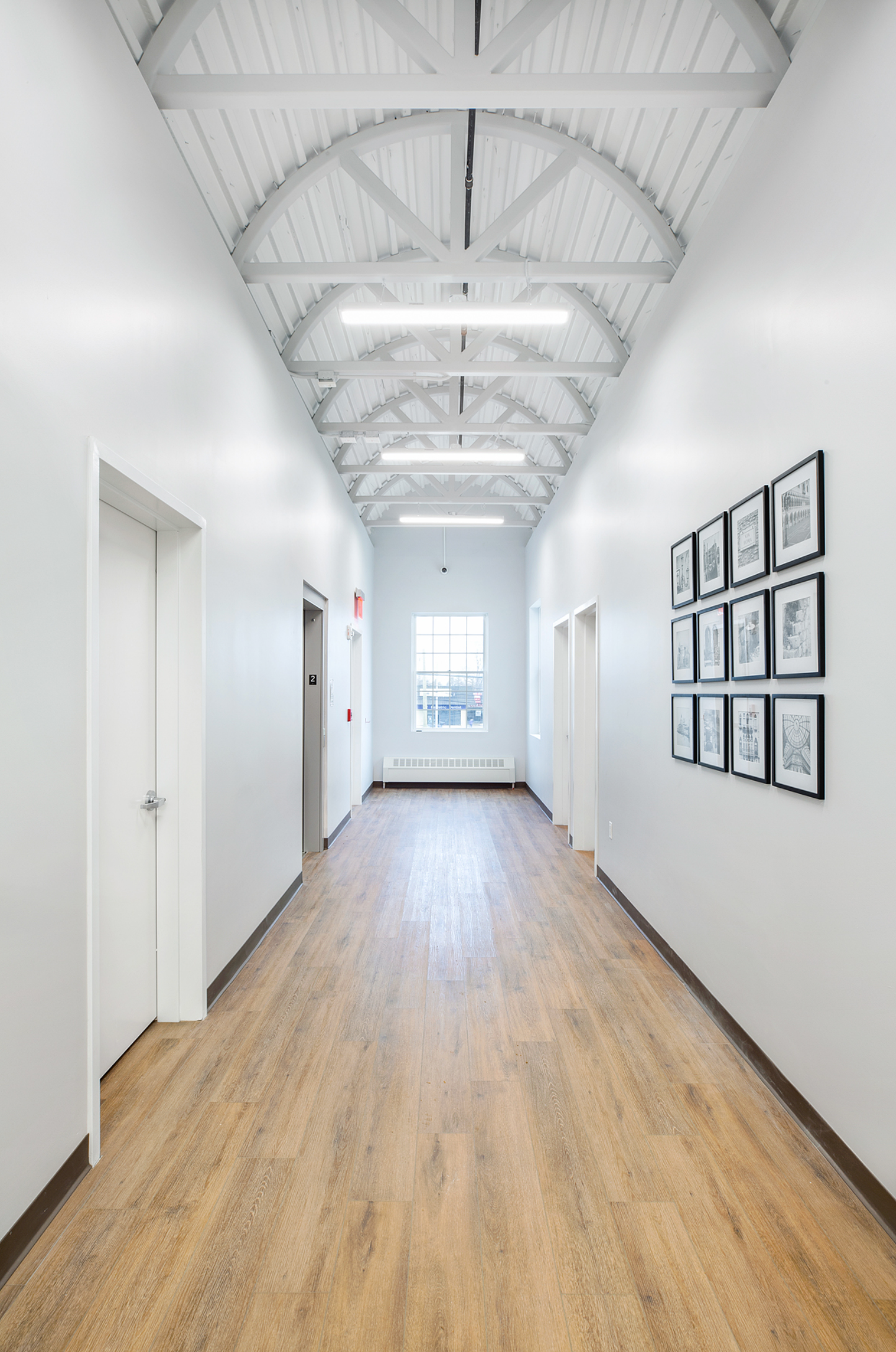 A long hallway with wooden floors and white walls.