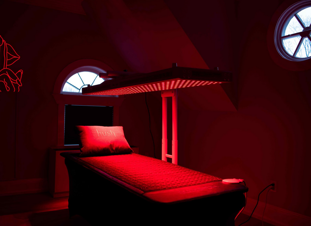 a bed with red lights on it in a dark room .