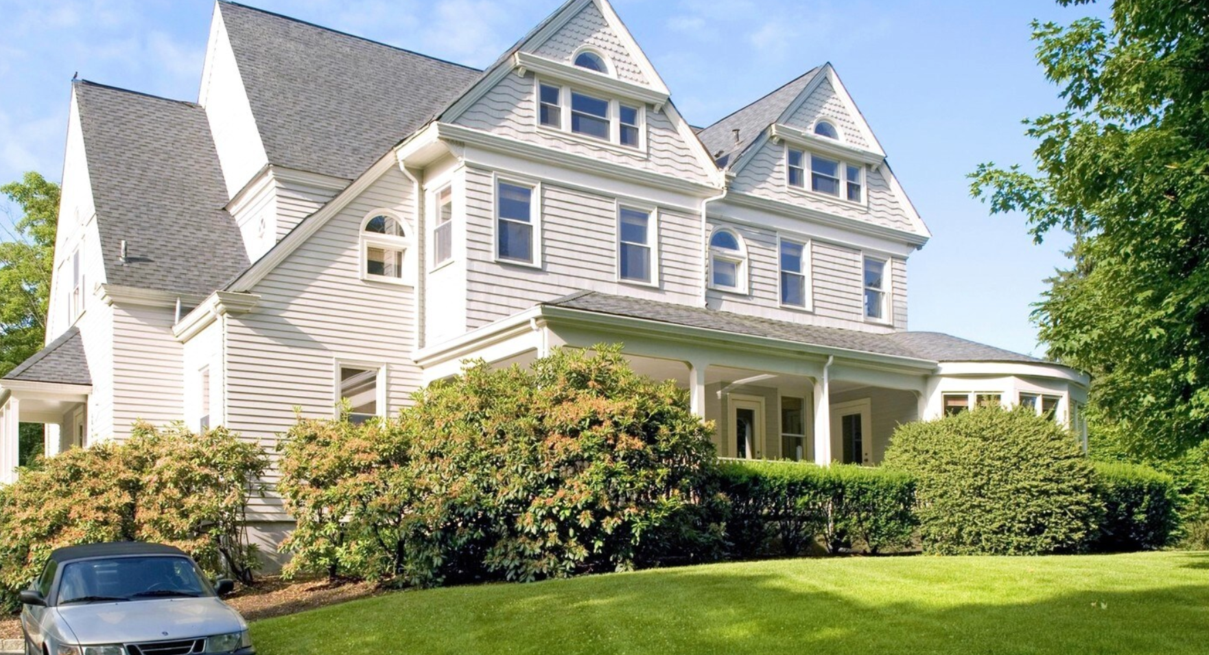 a large white house with a car parked in front of it