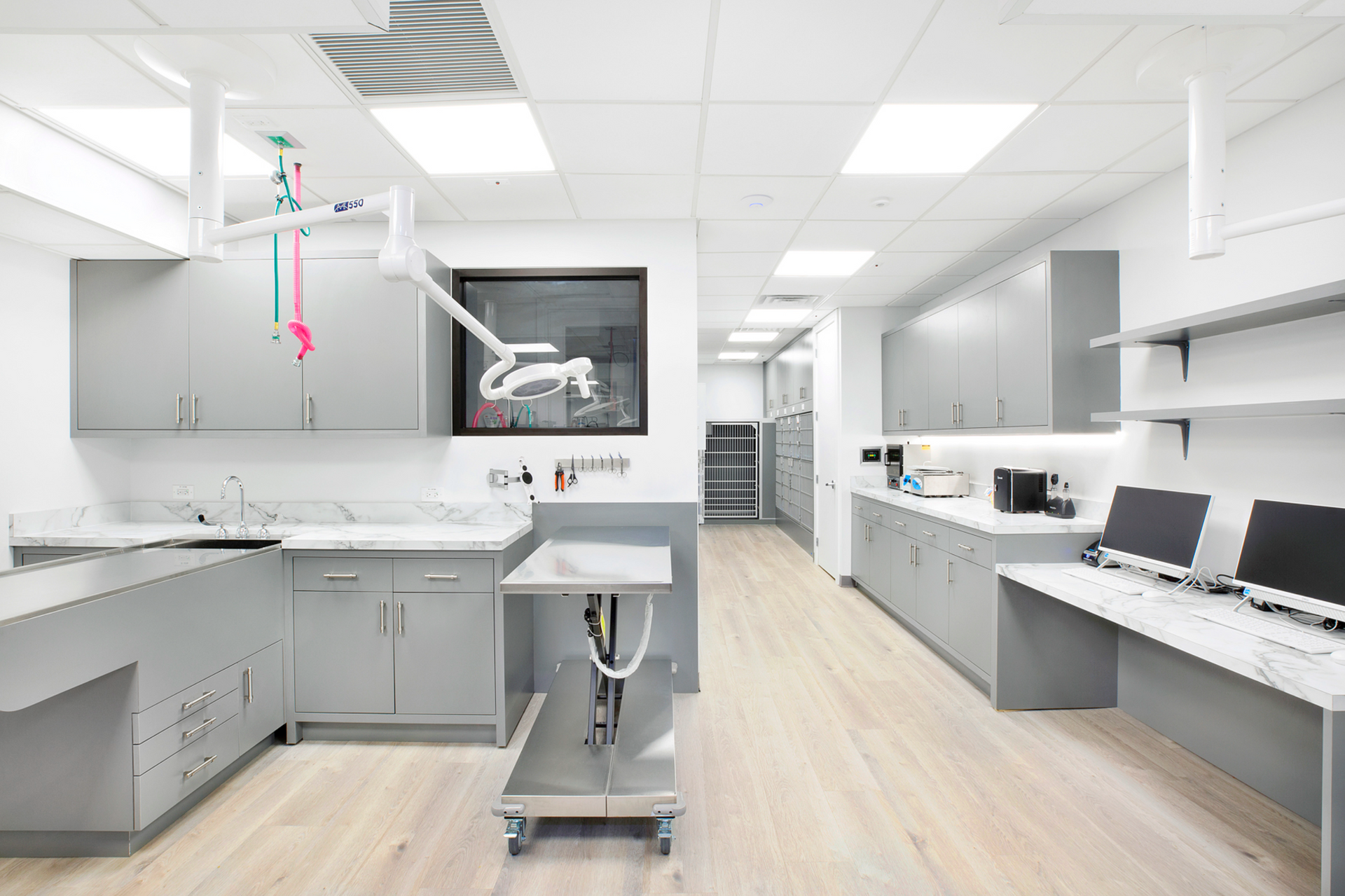 A large room with a lot of cabinets , desks , and computers.