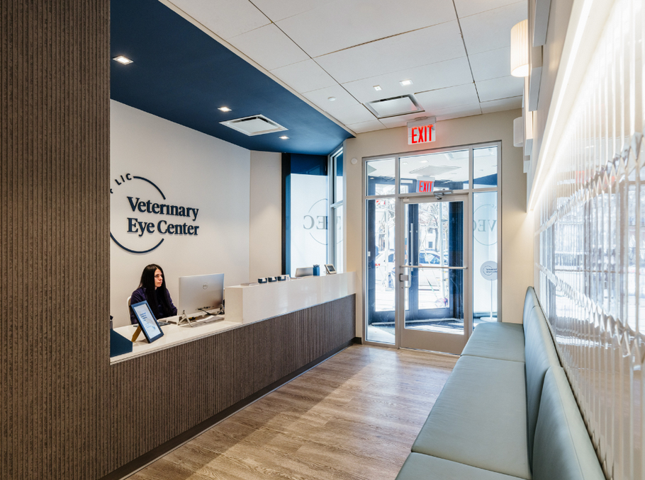 A woman is sitting at a desk in a veterinary eye center.