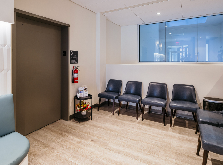 A waiting room with chairs and a fire extinguisher.
