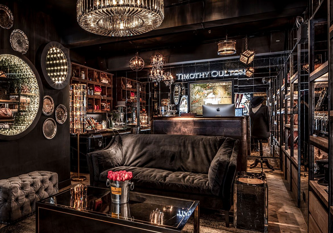 A living room with a black couch and a coffee table.