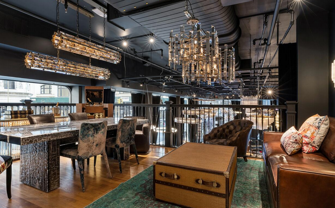 A living room with a couch , table , chairs and a chandelier.