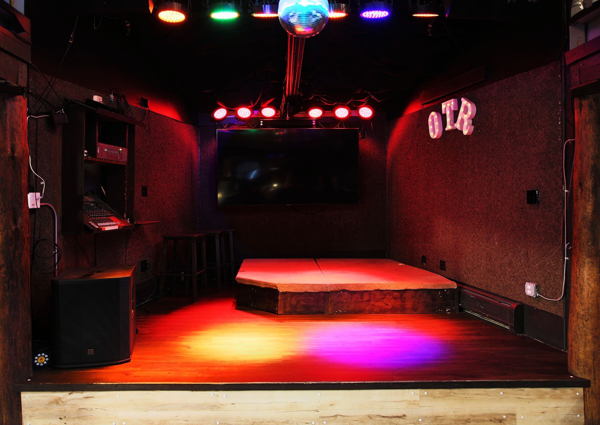 A stage in a dark room with the word ota on the wall