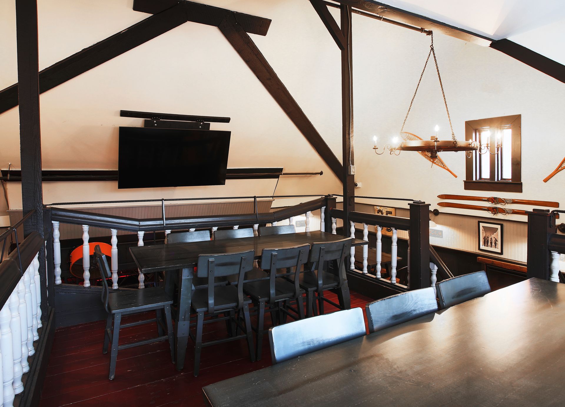 A room with a table and chairs and a television on the wall
